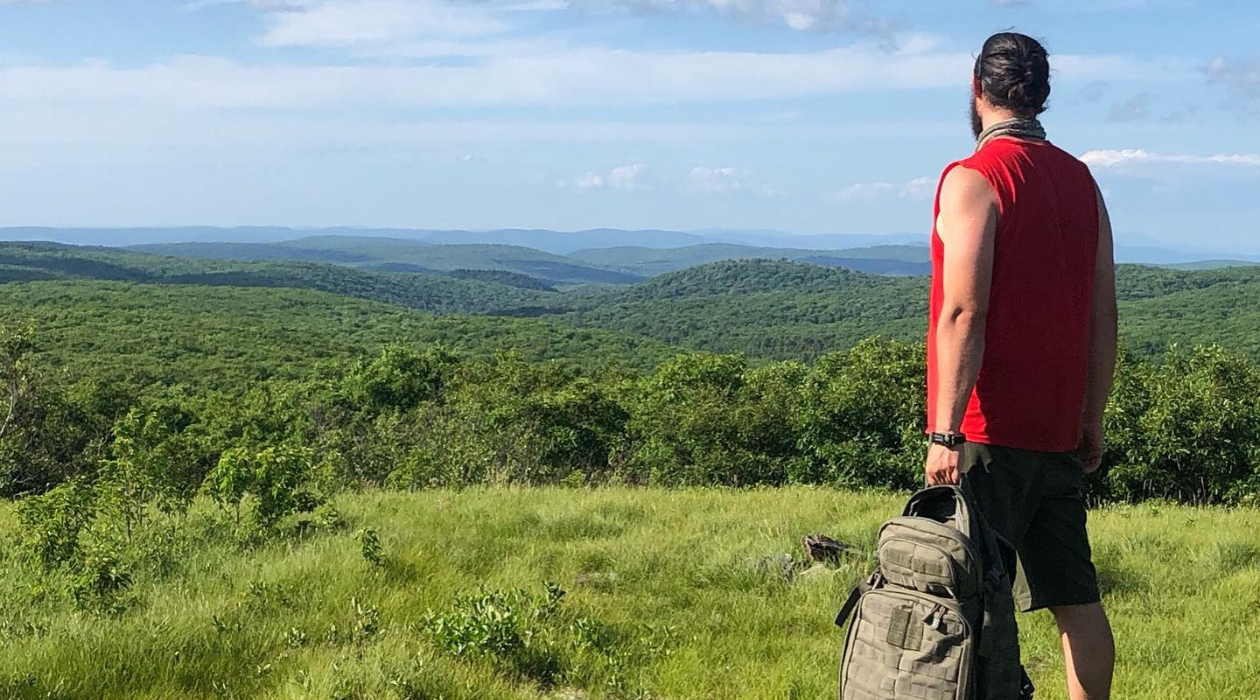 Man stands at summit of Brace Mountain